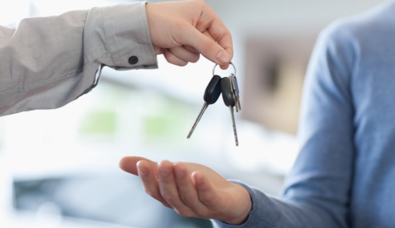 An image of a person handing car keys to another person.